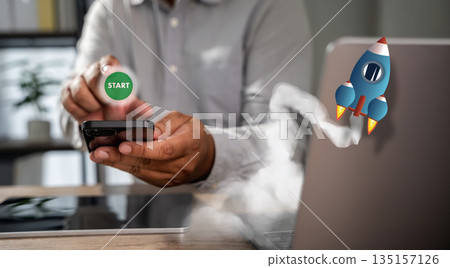 A person starting a task at desk, pressing start on a laptop or tablet, representing the beginning of digital workflow and focus. 135157126
