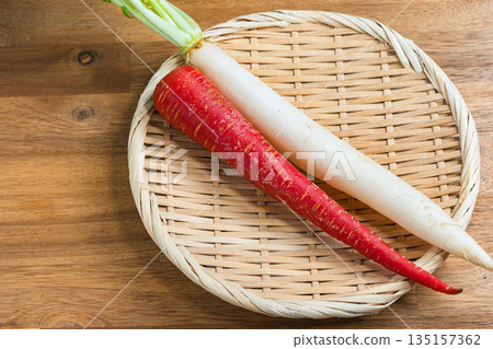 A red and white set of Kintoki carrots and zoni daikon radish served on a bamboo basket A red and white set of Kintoki carrots and zoni daikon radish served on a bamboo basket 135157362