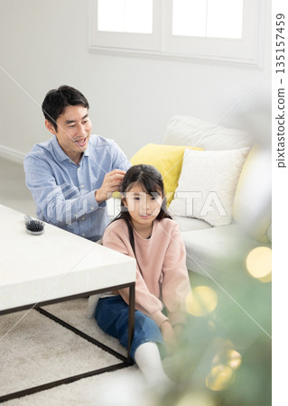 父親在客廳幫女兒紮頭髮 135157459