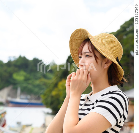 A woman wearing a straw hat looks out at the sea. (Photo courtesy of Oki Seaside Resort Miyabi) 135157549
