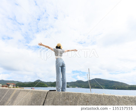 一位女子在沙灘上張開雙臂（照片由沖繩海濱度假村雅提供） 135157555
