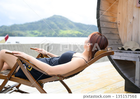 一位女士在湖邊放鬆 [照片由沖繩海濱度假村雅提供] 135157568