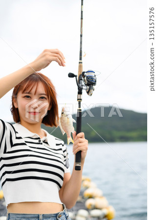 A smiling woman with a fish she caught (Photo courtesy of Oki Seaside Resort Miyabi) 135157576