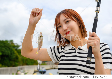 一位女士展示她釣到的魚。 （照片由沖繩海濱度假村雅提供） 135157580