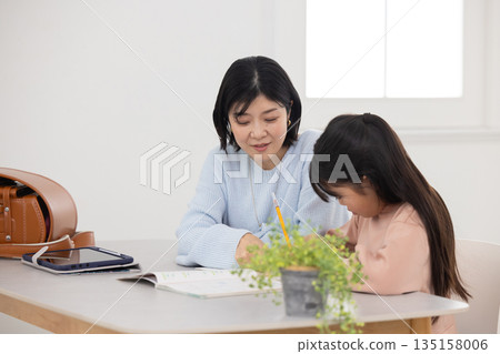 An elementary school girl being taught by her mother An elementary school girl being taught by her mother 135158006
