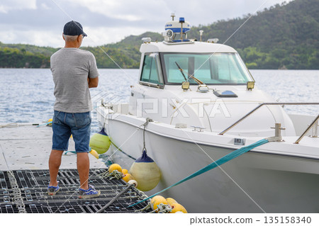 A man and a moored boat (Photo courtesy of Oki Seaside Resort Miyabi) 135158340