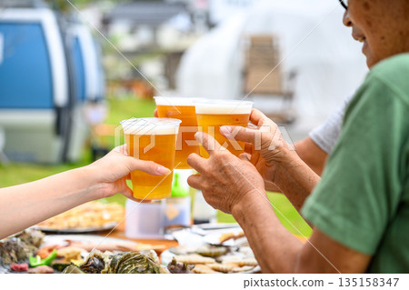 Toasting with beer outdoors [Photography cooperation: Oki Seaside Resort Miyabi] 135158347