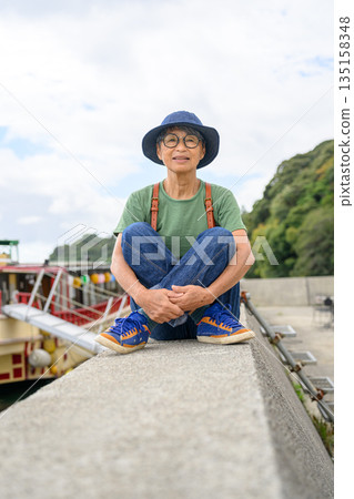 一位老婦人坐在港口邊（照片由沖繩海濱度假村雅提供） 135158348