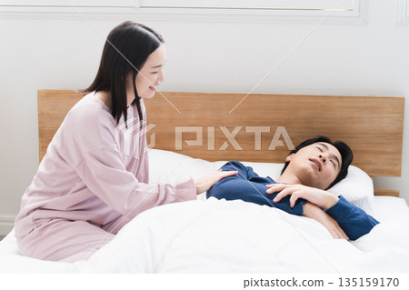 A young woman waking up a young man Lifestyle image A young woman waking up a young man Lifestyle image 135159170