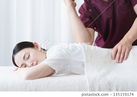 A young woman receiving a massage from a chiropractor Beauty image 135159174