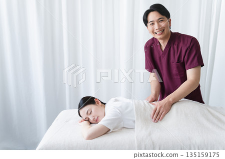 A young woman receiving a massage from a chiropractor Beauty image A young woman receiving a massage from a chiropractor Beauty image 135159175