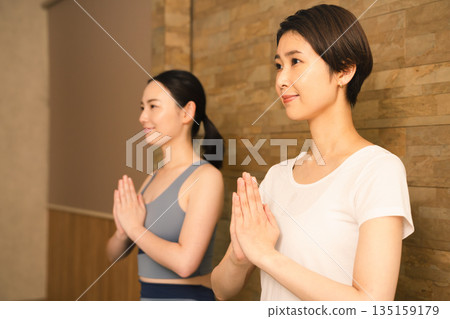 Two young women doing hot yoga. Beauty image. Two young women doing hot yoga. Beauty image. 135159179