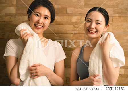 Two young women wiping sweat with a towel Beauty image 135159181