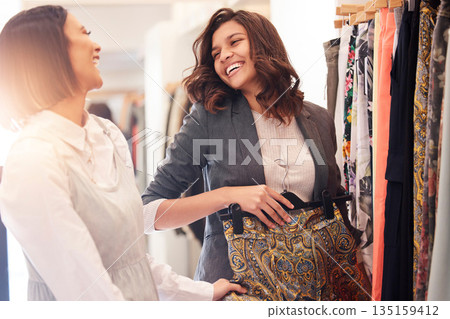 Fashion, retail and friends shopping in a mall together while searching for sales in a clothing store. Smile, happy or funny with a woman customer and friend in a shop to buy or purchase clothes Fashion, retail and friends shopping in a mall together while searching for sales in a clothing store. Smile, happy or funny with a woman customer and friend in a shop to buy or purchase clothes 135159412