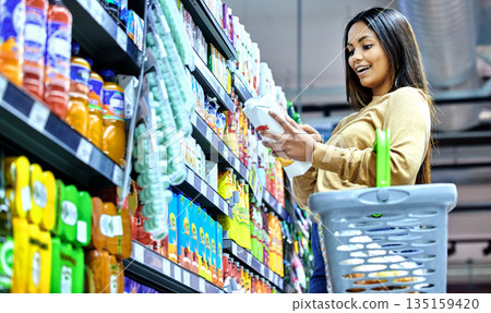 Grocery, shopping and wow with woman in supermarket for food, retail or label reading. Product, nutrition and health with female customer and basket in store for diet, discount and sale coupon 135159420