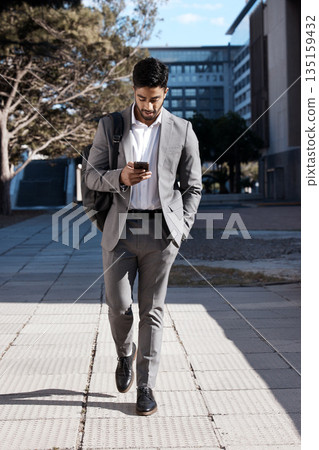 Phone, city and Indian business man walking for travel, social media or internet search. Smartphone, texting and male person on walk in town while checking app, message or text on commute in street 135159432