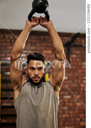 Fitness, exercise and man with kettle bell in gym for weightlifting, bodybuilder training or workout. Sports, strong muscle and serious male person lift weight for wellness, healthy body and strength Fitness, exercise and man with kettle bell in gym for weightlifting, bodybuilder training or workout. Sports, strong muscle and serious male person lift weight for wellness, healthy body and strength 135159489