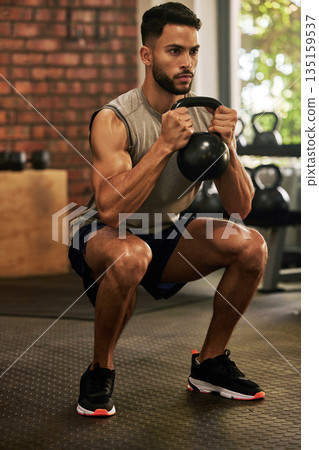 Squat, fitness and man with kettle bell in gym for exercise, bodybuilder training and workout. Sports, strong muscle and serious male person lifting weight for wellness, healthy body and strength 135159537