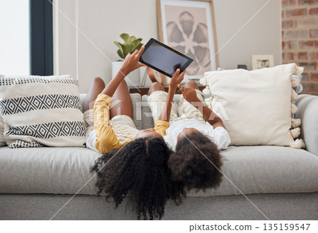 Relax, sisters and girl with a tablet, home and connection for social media, communication and chatting. Female children on a couch, young people and kids with technology, typing and watching videos Relax, sisters and girl with a tablet, home and connection for social media, communication and chatting. Female children on a couch, young people and kids with technology, typing and watching videos 135159547