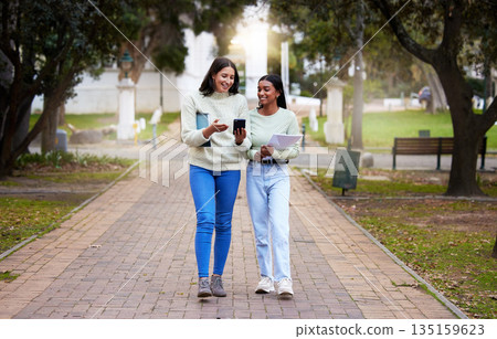 Happy, female students and friends with a smartphone walking together at university reading exam test results on a mobile app. Technology, smile and college girls on social media or chat on campus Happy, female students and friends with a smartphone walking together at university reading exam test results on a mobile app. Technology, smile and college girls on social media or chat on campus 135159623