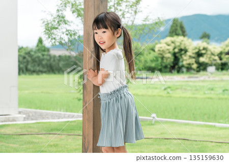 一個女孩在她家的花園裡玩耍 135159630