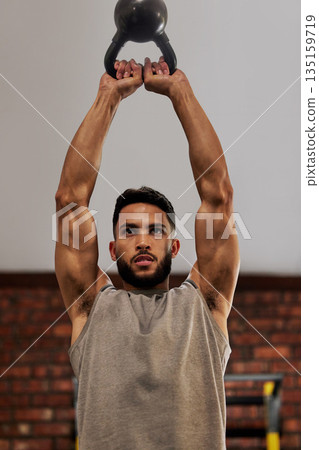 Muscle, fitness and man focus with kettlebell in gym for exercise, bodybuilder training and workout. Sports, strength and serious male person lift weight for wellness, healthy body and power 135159719
