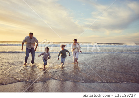 Beach, sunset and parents run with children on holiday, summer vacation and weekend together. Nature, travel and happy mother, father and kids play in ocean for bonding, adventure and family time Beach, sunset and parents run with children on holiday, summer vacation and weekend together. Nature, travel and happy mother, father and kids play in ocean for bonding, adventure and family time 135159727
