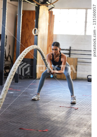 Fitness, battle rope or strong woman training for grip strength in workout or body exercise in gym club. Wellness, mindset or healthy female sports athlete with biceps power, resilience or focus 135160057