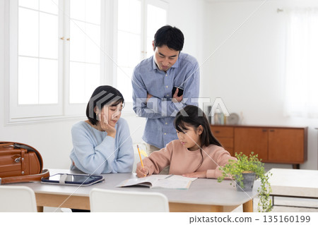 Parents with troubled expressions while teaching their children at home Parents with troubled expressions while teaching their children at home 135160199