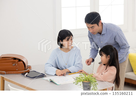 Parents with troubled expressions while teaching their children at home 135160211