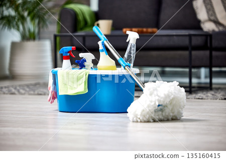 Cleaning, detergent and mop on the floor of a living room in a home for hygiene or service during housework. Product, bacteria and safety with supplies in a bucket ready to clean a house for service Cleaning, detergent and mop on the floor of a living room in a home for hygiene or service during housework. Product, bacteria and safety with supplies in a bucket ready to clean a house for service 135160415