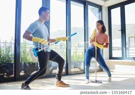 Couple, singing and cleaning home, dance and having fun playing with mop guitar and broom. Clean, dancing and happy man and woman, singer and chores, housekeeping together and happiness for music. 135160417