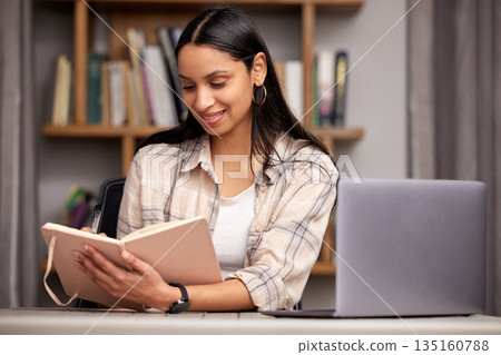 Laptop, book and education with a student woman in a university library to study for a final exam or test. Technology, learning and journal with a young female college pupil reading research material Laptop, book and education with a student woman in a university library to study for a final exam or test. Technology, learning and journal with a young female college pupil reading research material 135160788