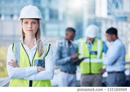 Portrait, arms crossed and a serious woman construction worker outdoor on a building site with her team in the background. Management, leadership and a confident female architect standing outside Portrait, arms crossed and a serious woman construction worker outdoor on a building site with her team in the background. Management, leadership and a confident female architect standing outside 135160999