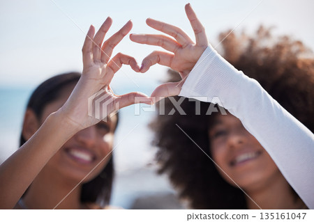 Friends, closeup and heart hands with women at beach for summer, happy and teamwork. Support, freedom and love with people and holding shape in outdoors for collaboration, faith and community gesture Friends, closeup and heart hands with women at beach for summer, happy and teamwork. Support, freedom and love with people and holding shape in outdoors for collaboration, faith and community gesture 135161047
