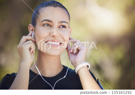 Earphones, runner or happy woman streaming music to start training, workout or running exercise in park. Smile, thinking or healthy sports girl athlete listening to radio or podcast about fitness Earphones, runner or happy woman streaming music to start training, workout or running exercise in park. Smile, thinking or healthy sports girl athlete listening to radio or podcast about fitness 135161292