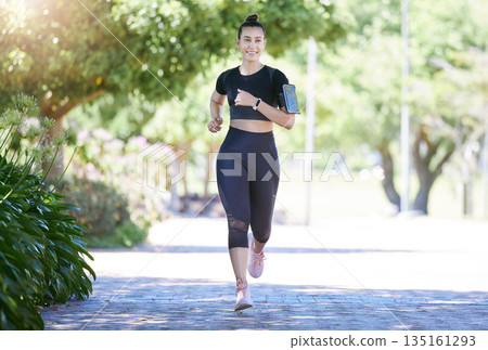 Phone, fitness or happy woman running in park training, cardio exercise or full body workout for marathon. Wellness, athlete runner smiling or healthy sports girl exercising on jog outdoors in nature 135161293