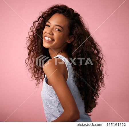 Hair care, portrait and woman in a studio with a natural, long and curly beauty salon hairstyle. Happy, smile and brunette female model with a keratin cosmetic treatment isolated by pink background. Hair care, portrait and woman in a studio with a natural, long and curly beauty salon hairstyle. Happy, smile and brunette female model with a keratin cosmetic treatment isolated by pink background. 135161322
