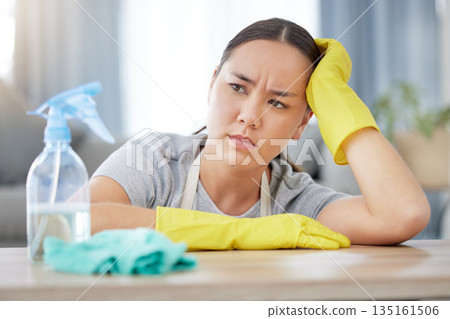 Thinking, annoyed and cleaning with a woman housekeeper using disinfectant to remove bacteria in a home. Idea, frustrated and hygiene with a young female cleaner working in a living room for service Thinking, annoyed and cleaning with a woman housekeeper using disinfectant to remove bacteria in a home. Idea, frustrated and hygiene with a young female cleaner working in a living room for service 135161506