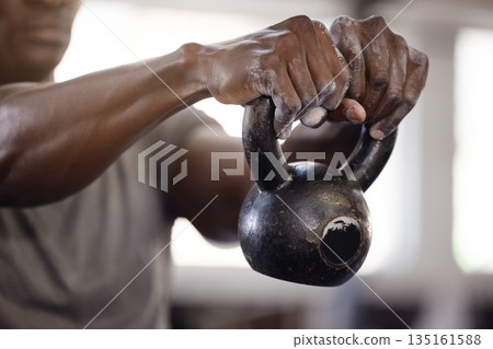 Kettlebell, hands and exercise with a man at gym for fitness, training and strong muscle growth. Athlete or bodybuilder person at club for iron weights workout for power and performance with powder Kettlebell, hands and exercise with a man at gym for fitness, training and strong muscle growth. Athlete or bodybuilder person at club for iron weights workout for power and performance with powder 135161588