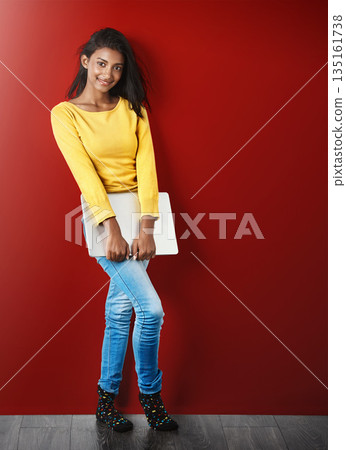 Student woman, portrait and laptop by wall with smile for learning, education or research for development. Gen z gIrl, computer and happy for study, elearning and social network app by red background 135161738