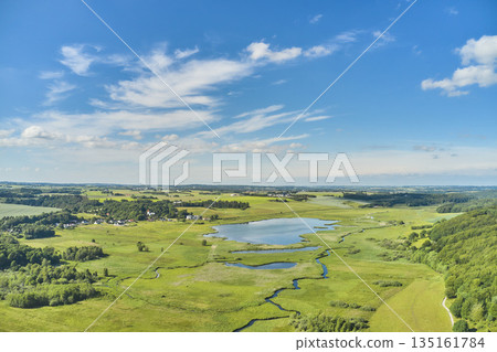 Nature, lake and environment with drone of countryside for agriculture, farming and summer. Grass, travel and landscape with aerial view of meadow field and blue sky for growth, plants and ecology Nature, lake and environment with drone of countryside for agriculture, farming and summer. Grass, travel and landscape with aerial view of meadow field and blue sky for growth, plants and ecology 135161784
