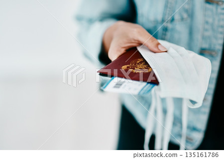 Covid, person and hands with passport, face mask and protection for boarding pass at airport. Closeup, travel and tourists journey of passenger with personal visa for safety, security or safeguarding 135161786