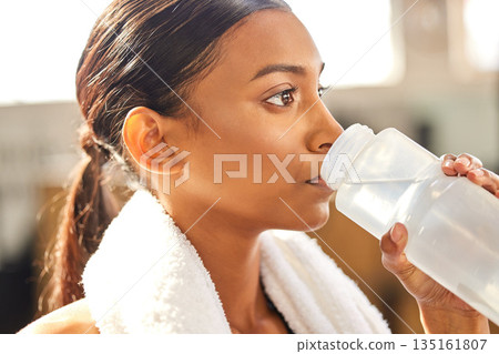 Thirsty, fitness or Indian woman drinking water at gym in training, workout or exercise to hydrate her body. Fatigue, face or tired girl with bottle for healthy liquid hydration on resting break 135161807