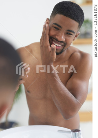 Happy man, face and beauty with mirror and skincare, hygiene and grooming during morning routine at home. Black male person smile in bathroom, fresh and clean facial with wellness and moisturizing Happy man, face and beauty with mirror and skincare, hygiene and grooming during morning routine at home. Black male person smile in bathroom, fresh and clean facial with wellness and moisturizing 135161878