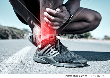 Fitness, ankle and injury with a sports man holding his joint in pain while outdoor for a workout. Exercise, emergency and accident with a male athlete feeling tender while training for recreation 135161900