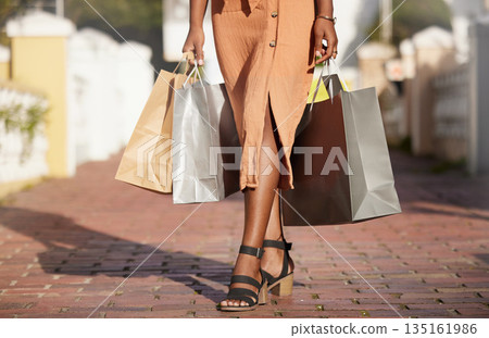 Feet closeup, shopping and woman with bags on sidewalk, retail and customer at discount deal at luxury store. City lady with designer boutique paper bag at fashion sale with shoes and clothes on path Feet closeup, shopping and woman with bags on sidewalk, retail and customer at discount deal at luxury store. City lady with designer boutique paper bag at fashion sale with shoes and clothes on path 135161986