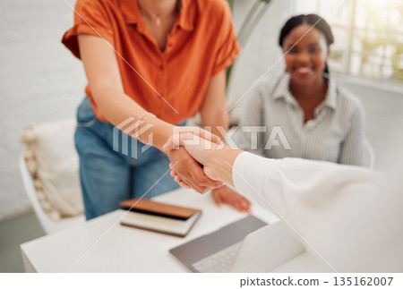 Business people with a handshake in the office for corporate deal, partnership or collaboration. Meeting, welcome and closeup of female employees shaking hands for an onboarding, hiring or agreement. Business people with a handshake in the office for corporate deal, partnership or collaboration. Meeting, welcome and closeup of female employees shaking hands for an onboarding, hiring or agreement. 135162007