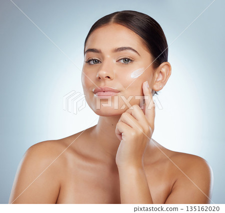 Skincare, face and woman with cream in studio isolated on a white background. Portrait, dermatology lotion and female model apply beauty cosmetics, sunscreen or moisturizer product for skin health. Skincare, face and woman with cream in studio isolated on a white background. Portrait, dermatology lotion and female model apply beauty cosmetics, sunscreen or moisturizer product for skin health. 135162020