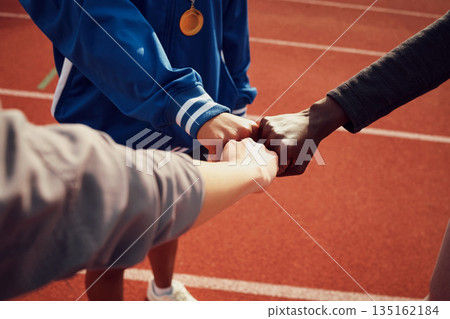People, diversity and fist bump in fitness for unity, trust or support together on stadium track. Hands of group touching fists in team building for sports motivation, teamwork or goals outdoors People, diversity and fist bump in fitness for unity, trust or support together on stadium track. Hands of group touching fists in team building for sports motivation, teamwork or goals outdoors 135162184